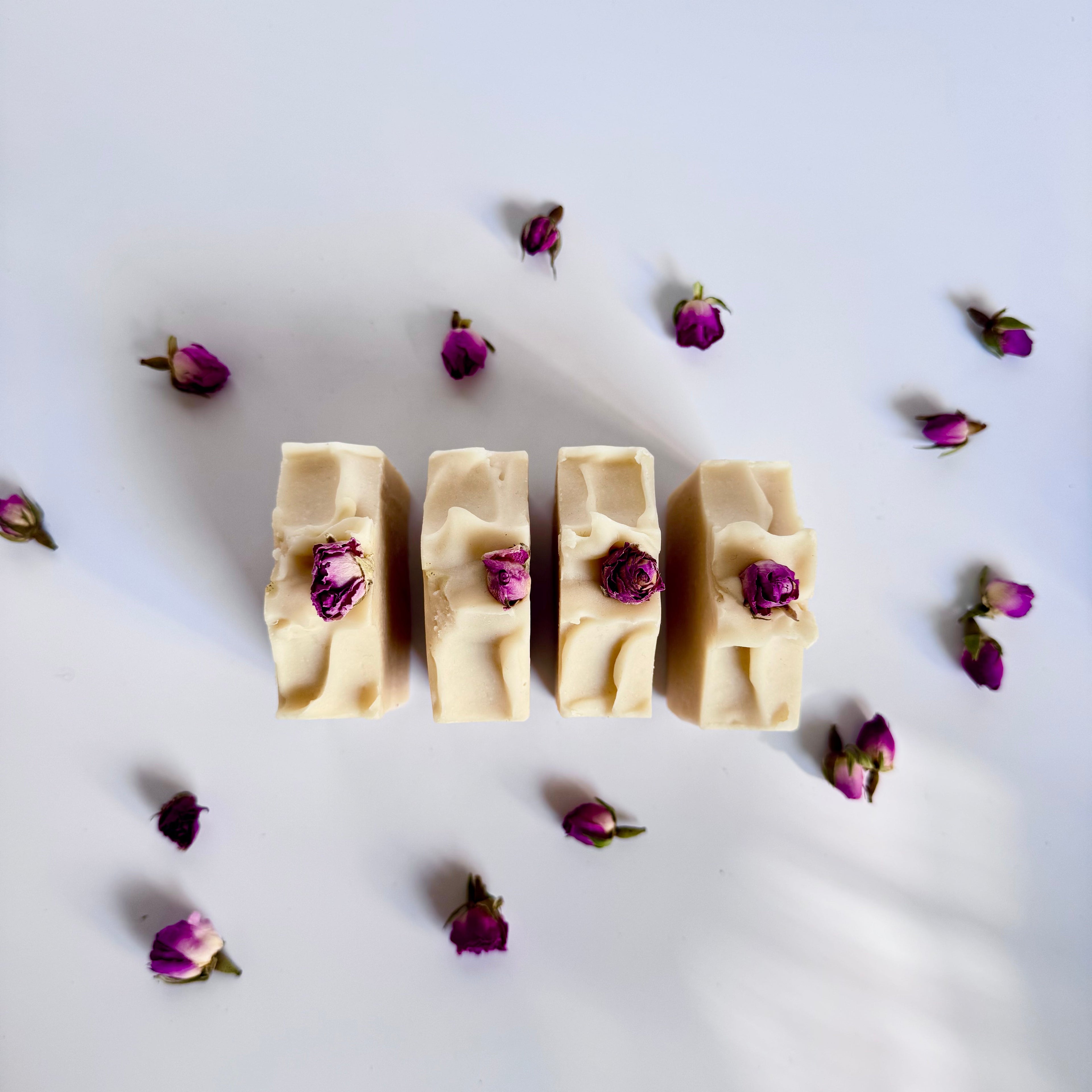 White handmade natural soap bars with dried rose buds