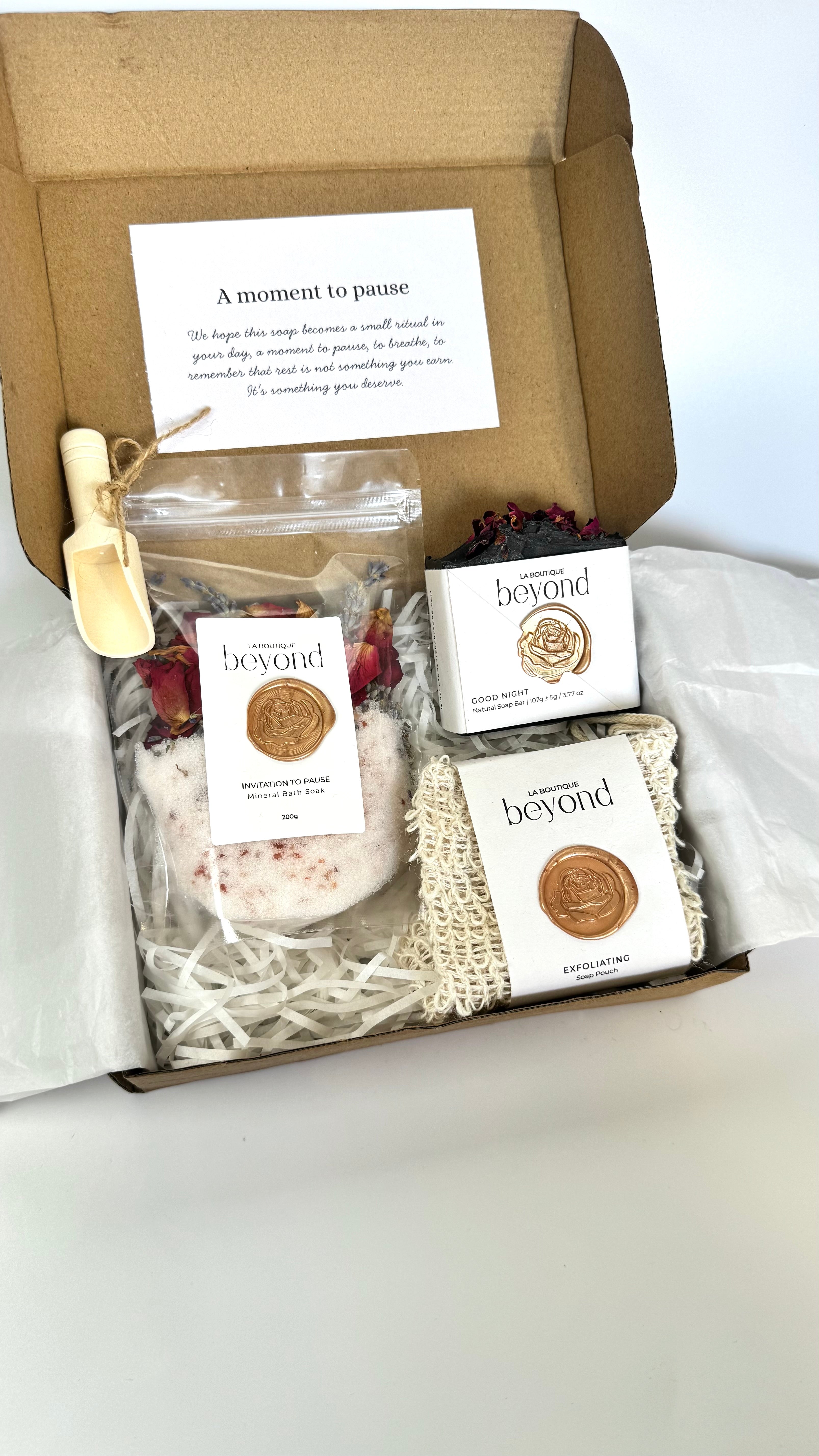 Black activated charcoal lavender tea tree soap bar with soap pouch and bath soak to choose from for the gift set box of 'La Boutique Beyond' coffee packages on a light gray background 