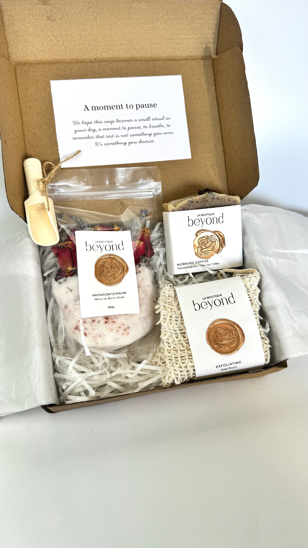 Brown coffee soap bar with soap pouch and bath soak to choose from for the gift set box of 'La Boutique Beyond' coffee packages on a light gray background 