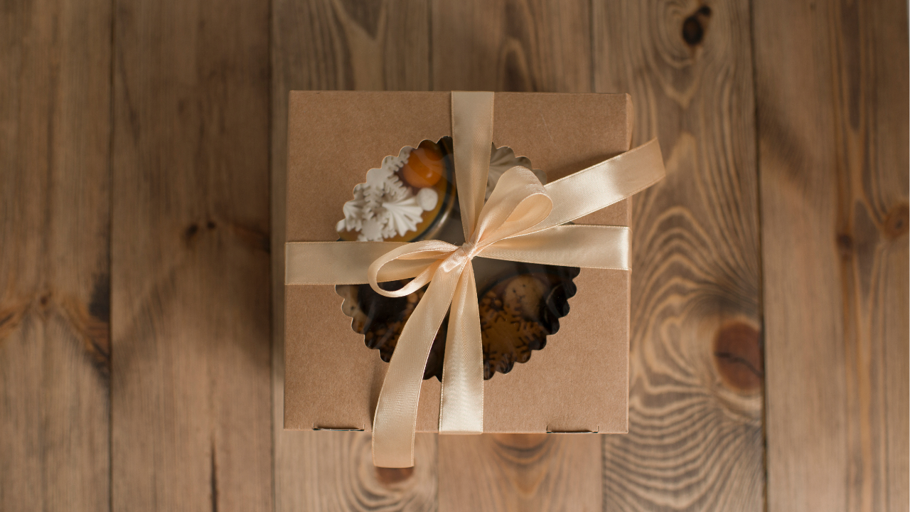 Gift box with a plant and decorative items on a wooden surface