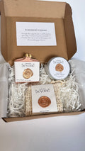 Gift set with pink rose geranium chamomile soap bar, mini travel soaps and soap pouch and a packaging labeled 'La Boutique Beyond' inside a brown box on a white background 