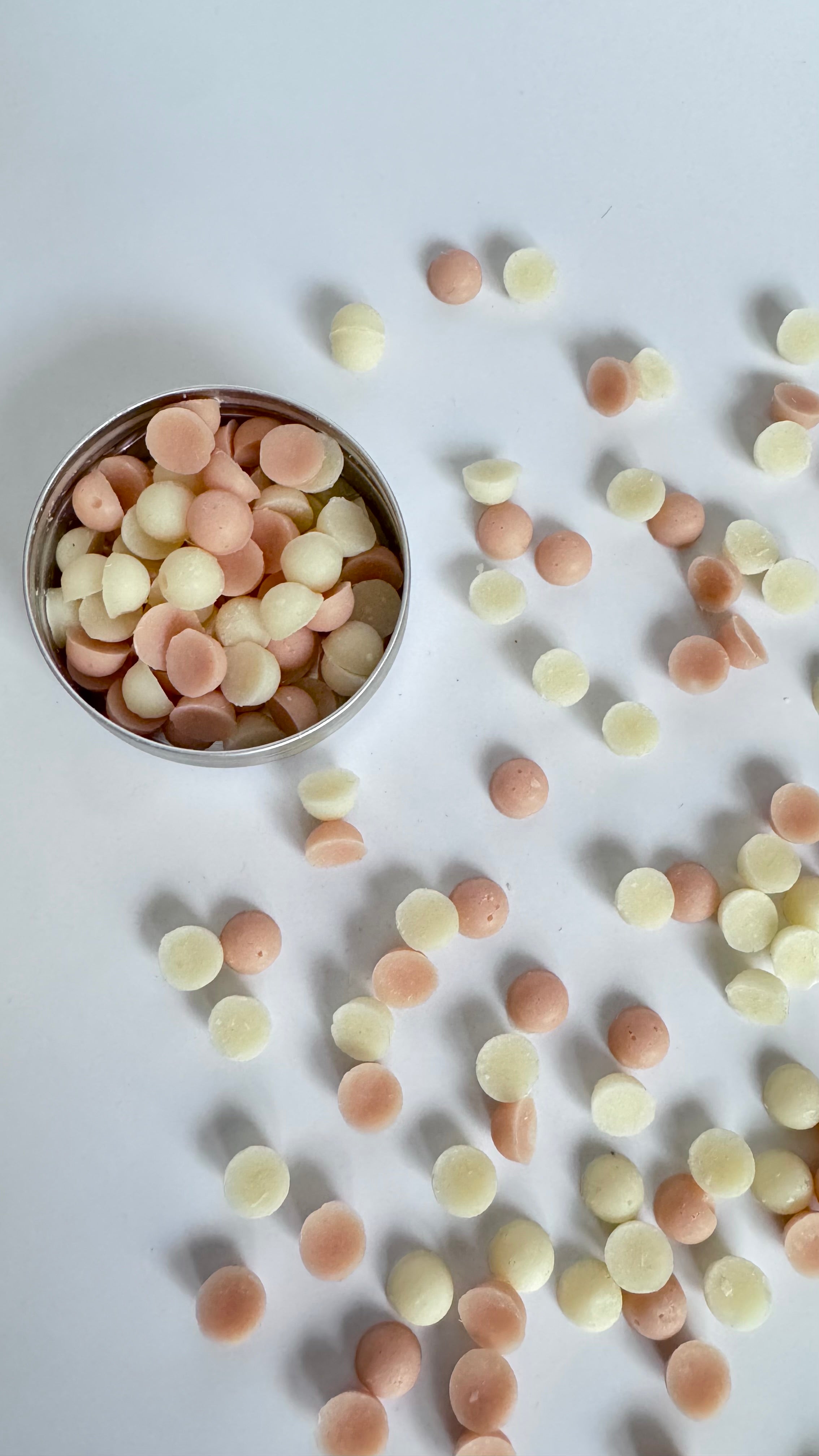 Mix tin box of pink and white rose coconut mini travel soap beads in a round tin box on light background