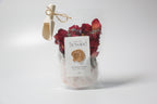 Pouch of natural bath soak, Epsom salt Himalayan pink salt with dried red rose petals, lavender buds with 'La Boutique Beyond' label on a white background