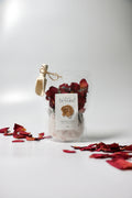 Bag of natural bath soak, Epsom salt Himalayan pink salt with dried red rose petals, lavender buds with 'La Boutique Beyond' label on a white background