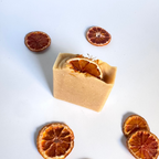 Orange turmeric natural soap bar with dried orange slices on a white background 
