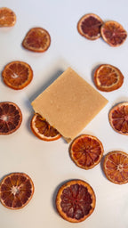 Orange turmeric natural soap bar above view flat with dried orange slices on a white background 