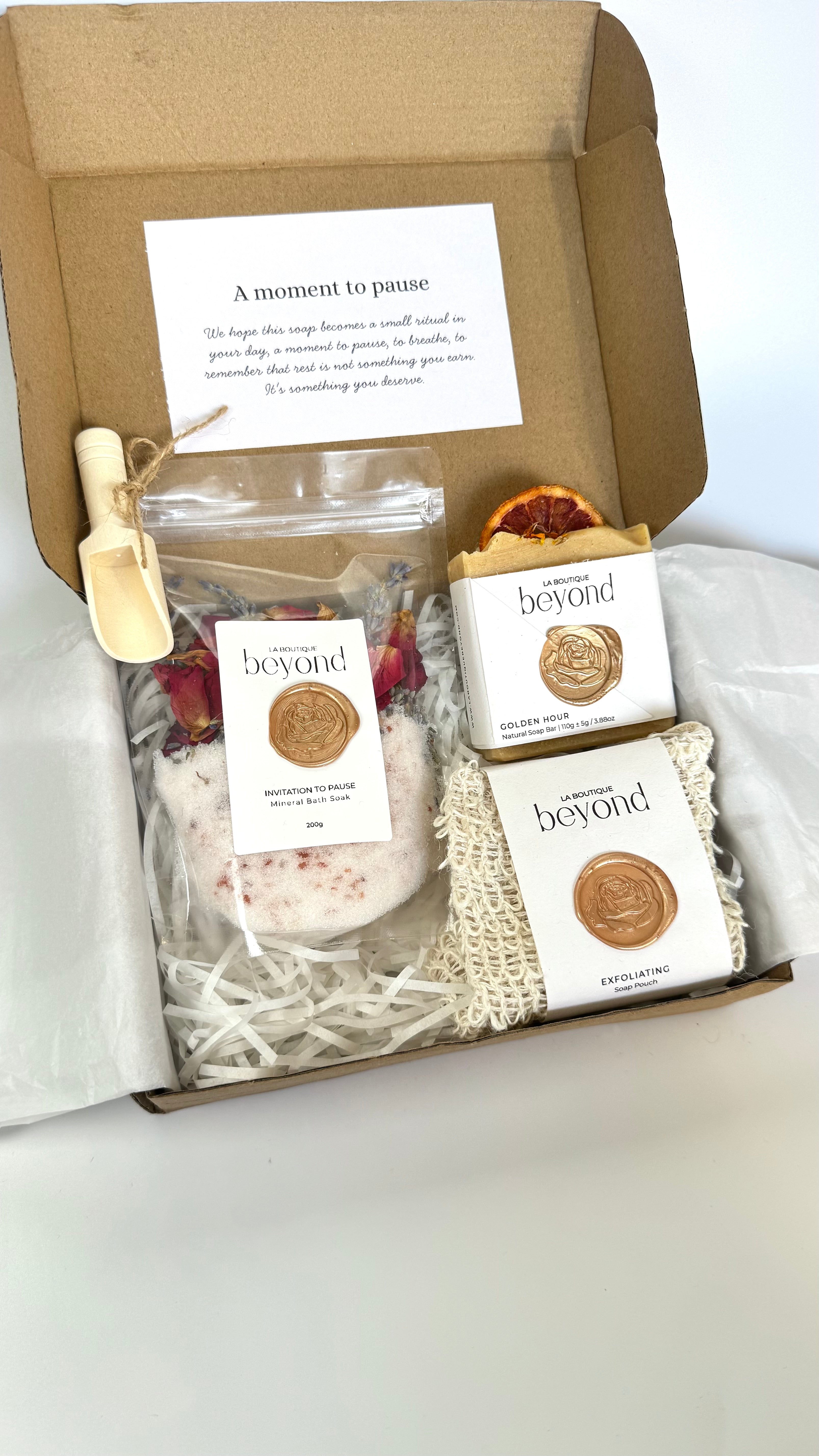 Orange turmeric soap bar with soap pouch and bath soak to choose from for the gift set box of 'La Boutique Beyond' coffee packages on a light gray background 