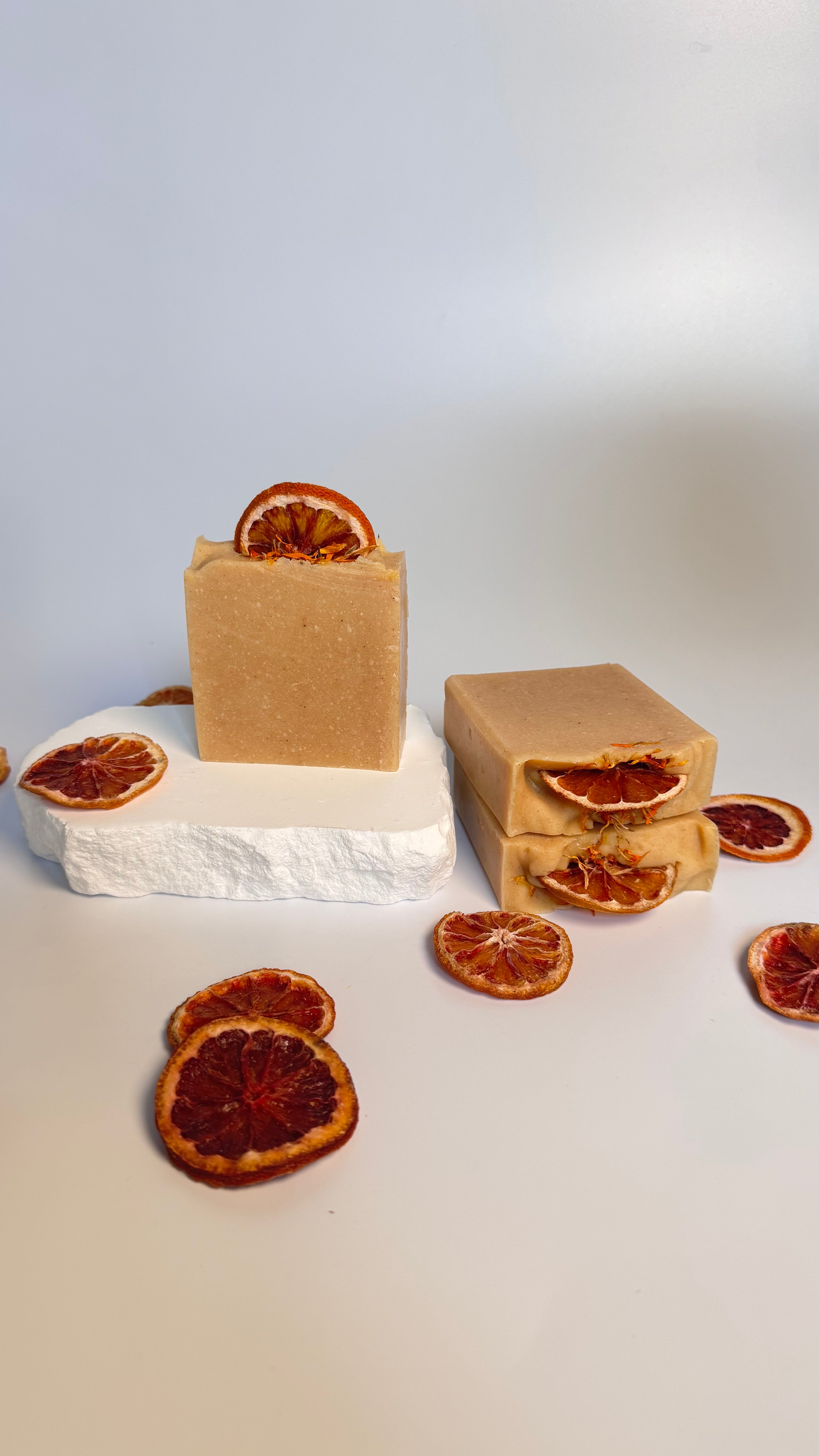 Three orange turmeric natural soap bar with dried orange slices on a white background 