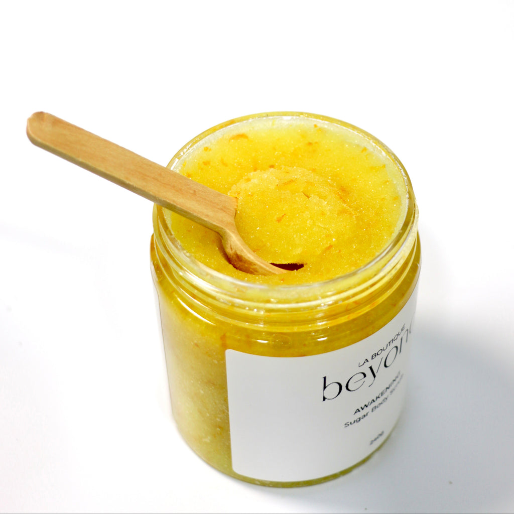 Open jar of orange zest sugar body scrub on a white background
