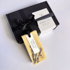 Bar of soap with lavender and a 'Thank You' card, tied to a black gift box on a white background.