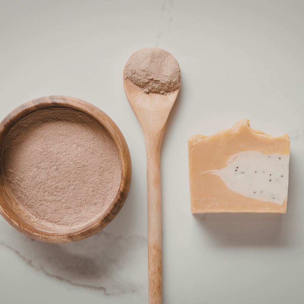 Wooden bowl, spoon, and soap bar on a light background